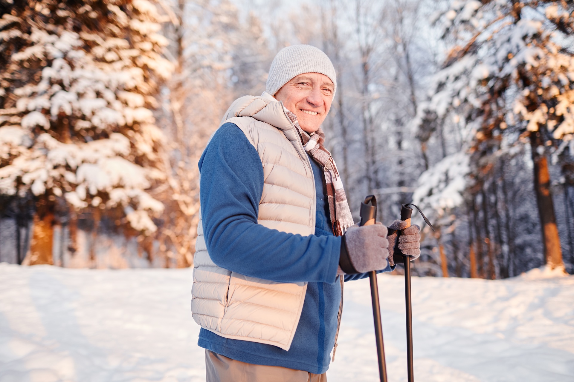 Senior cieszy się zimą, uprawiając nordic walking