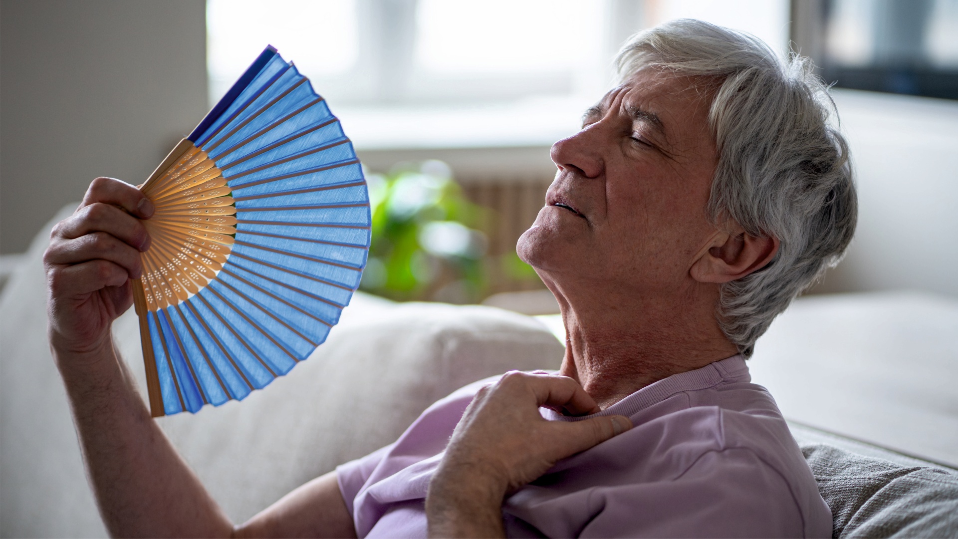 Seniorka w domu, wachluje się, bo jest jej bardzo gorąco